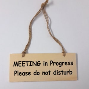 Peut inclure: Panneau rectangulaire en bois avec le texte "MEETING in Progress Please do not disturb" en lettres noires. Le panneau est suspendu par une ficelle en corde naturelle, idéal pour accrocher à une porte ou un mur.