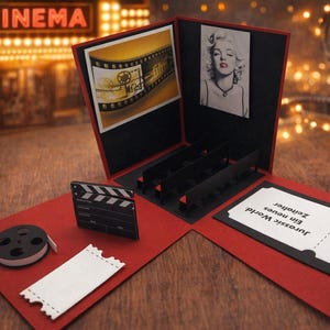 Könnte beinhalten: Rote und schwarze Pop-up-Karte zum Thema Kino mit Filmrolle, Klappe und Ticket. Die Karte zeigt Bilder eines Filmstreifens und Marilyn Monroe. Der Hintergrund zeigt ein Kinoplakat.