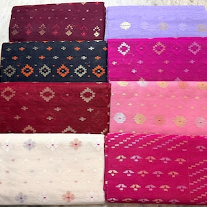 May include: An assortment of colorful fabric pieces, each folded and displaying a unique pattern. The fabrics vary in shades of red, pink, purple, and blue, with intricate geometric and floral designs. The textiles are likely suitable for sewing or crafting projects.