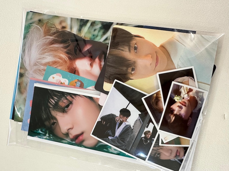 May include: A collection of photo cards featuring various images of young men. The cards are arranged in a clear plastic sleeve.