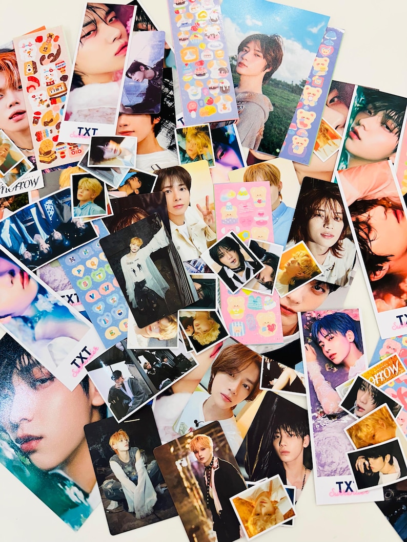 May include: A collection of colorful photo cards featuring various K-pop idols. The cards are decorated with stickers and text, including the words "TXT" and "Tomorrow X Together".
