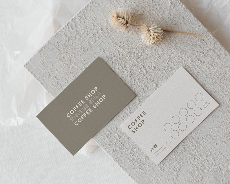 May include: Two brown and white business cards with the text "Coffee Shop" on them. One card has a simple design and the other has a punch card with eight circles.