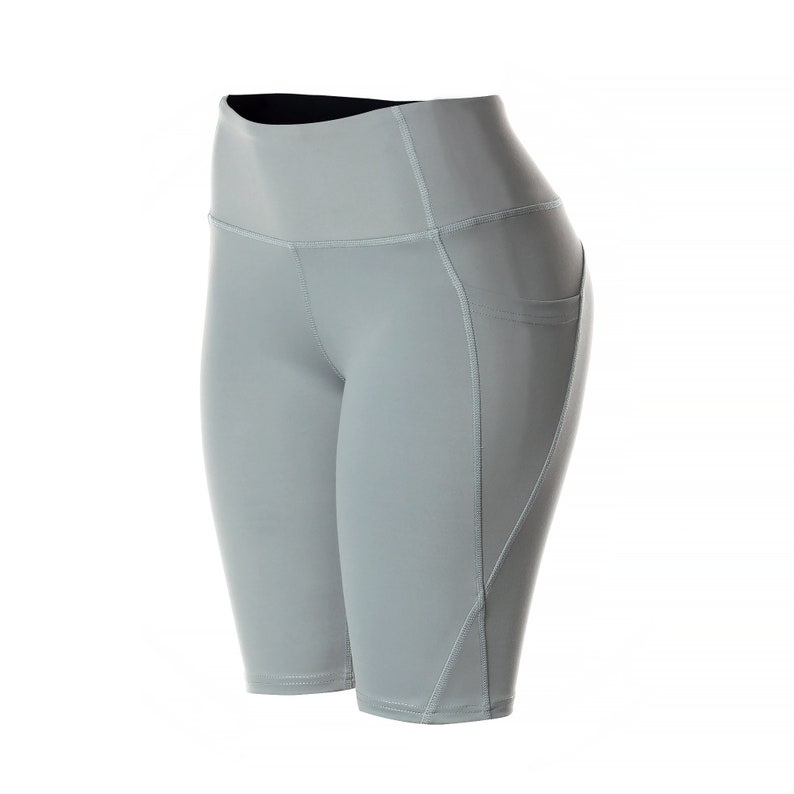 May include: Gray athletic shorts with a high waist and a pocket on the right side.
