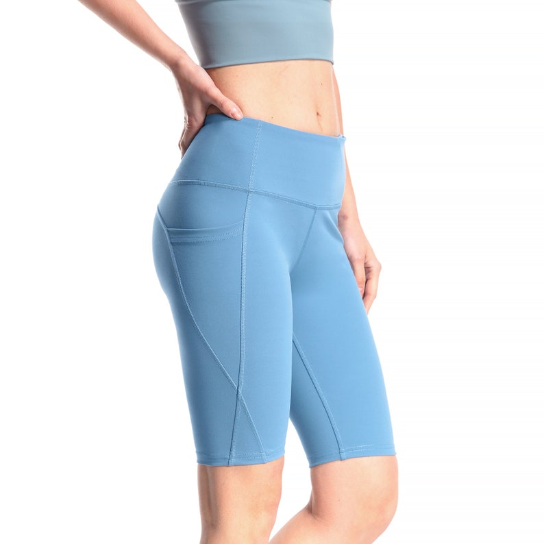 May include: A pair of light blue athletic shorts with a high waist and a side pocket. The shorts are made of a stretchy, comfortable material.
