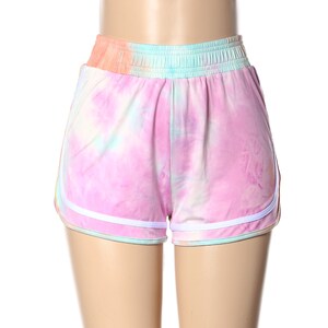 May include: Pink tie-dye shorts with white trim. The shorts have an elastic waistband and a relaxed fit.