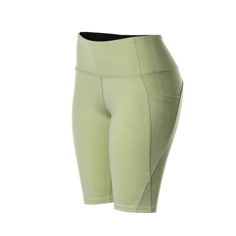 May include: Light green athletic shorts with a high waist and a pocket on the right side.