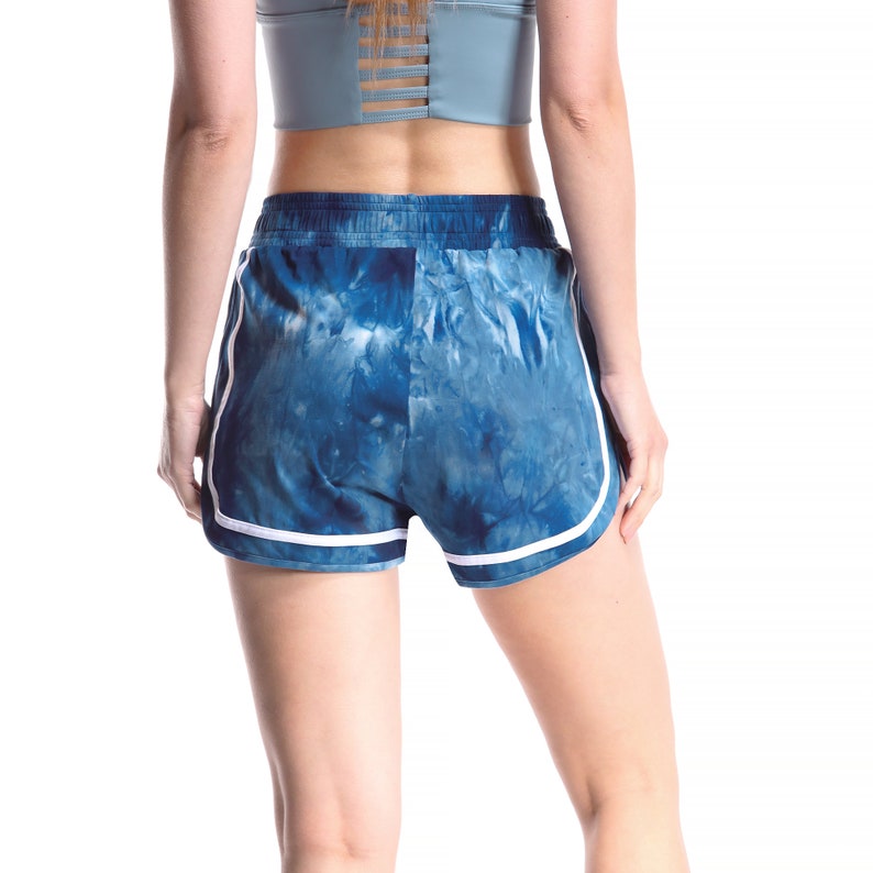 May include: Blue and white tie-dye athletic shorts with white trim. The shorts have a drawstring waistband.