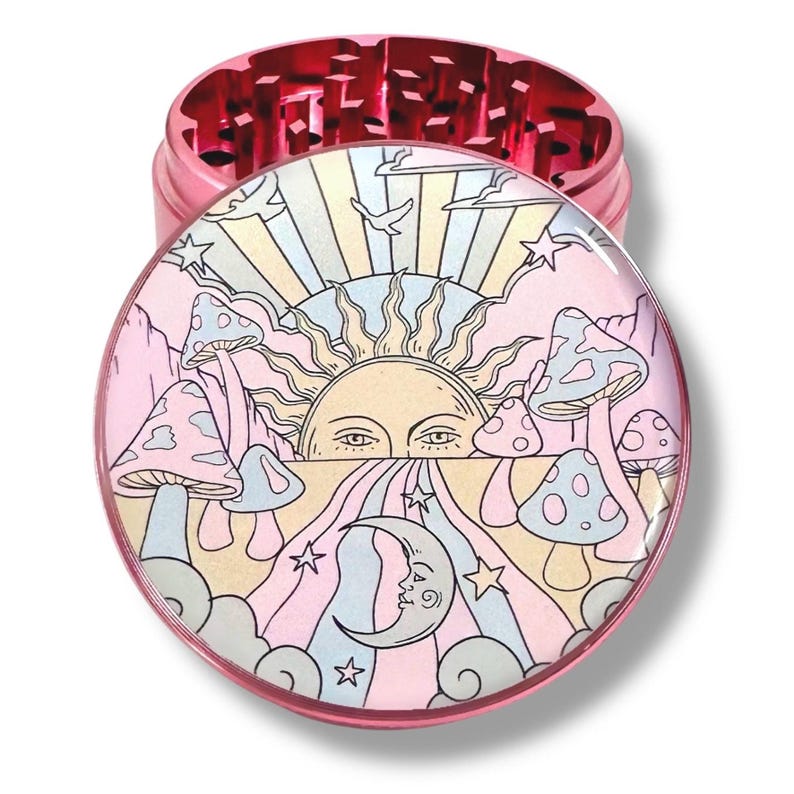 Peut inclure: Broyeur &agrave; herbes rose avec un motif psych&eacute;d&eacute;lique color&eacute;. Le dessus pr&eacute;sente une illustration d&eacute;taill&eacute;e d'un soleil, d'une lune, de champignons et de nuages aux couleurs pastel. Le broyeur est en m&eacute;tal.