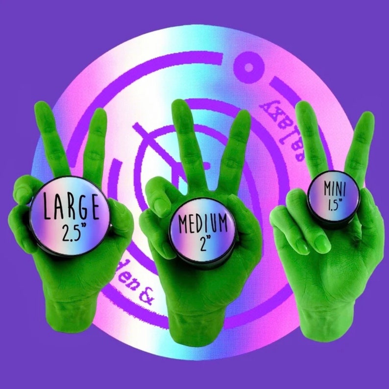 Peut inclure: Trois mains vertes en signe de paix tiennent des objets circulaires avec les inscriptions "LARGE 6.35 cm", "MEDIUM 5.08 cm" et "MINI 3.81 cm". Les objets ont une surface holographique iris&eacute;e. Le fond est violet avec un motif circulaire.