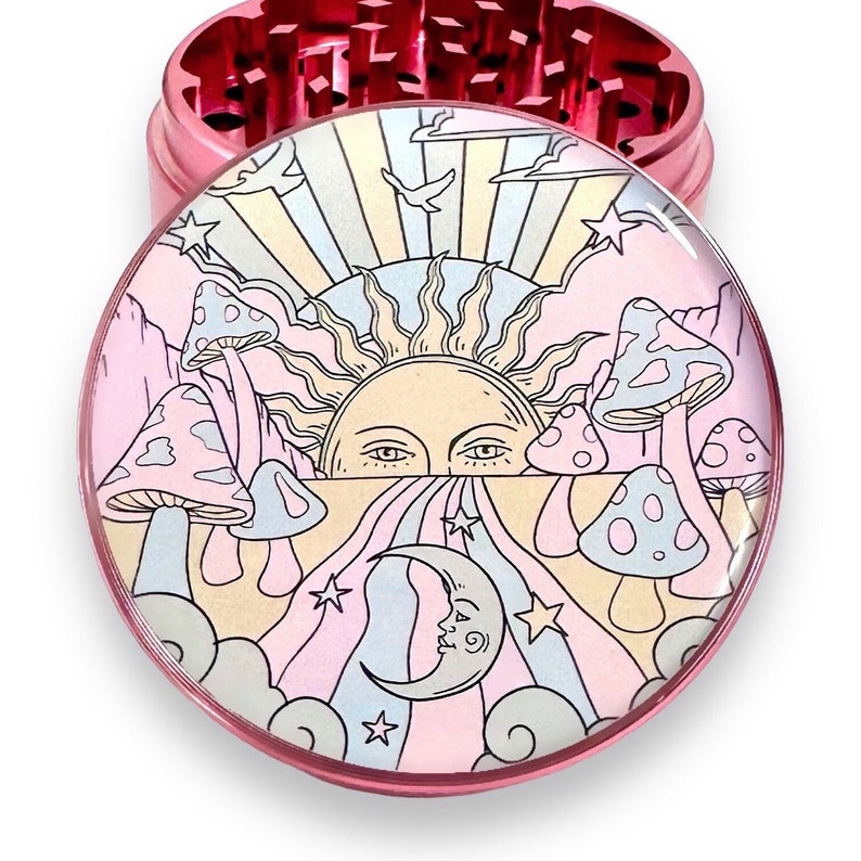 Peut inclure: Broyeur en m&eacute;tal rose avec un motif psych&eacute;d&eacute;lique color&eacute;. Le motif repr&eacute;sente un soleil avec des yeux, des champignons, un croissant de lune, des &eacute;toiles et des nuages aux couleurs pastel. Le broyeur est rond et comporte une partie sup&eacute;rieure et inf&eacute;rieure.