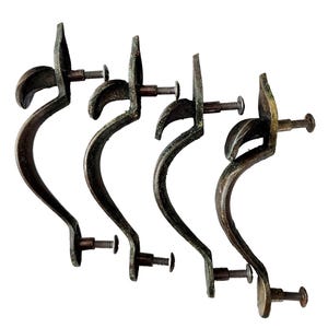 May include: Four antique bronze-colored drawer pulls with curved handles and decorative leaf-like accents. Each pull includes a screw for mounting. The pulls have a vintage, aged appearance.