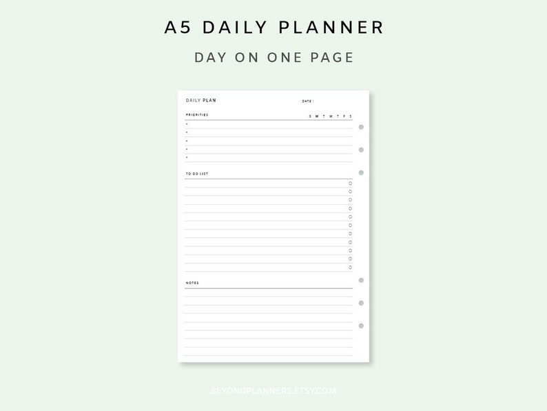 May include: A white A5 daily planner with a black header that reads "A5 Daily Planner Day on One Page". The planner has sections for "Daily Plan", "Priorities", "To Do List", and "Notes".