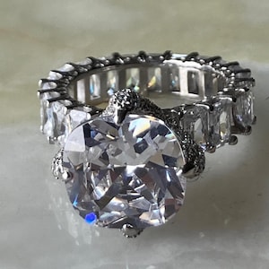 May include: A set of three ceramic mugs with a speckled, matte finish. The mugs are in shades of cream, light gray, and dark gray. Each mug has a simple, minimalist design and a rounded handle. Perfect for coffee or tea.