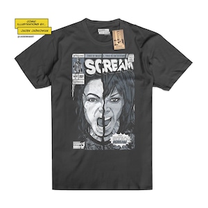 May include: A dark grey t-shirt featuring a comic book cover design with a woman's face split in half, screaming. The comic book cover is titled "Scream" and has the text "Tired of injustice, tired of the schemes".