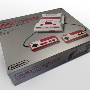 May include: A silver box featuring a white and red Nintendo Family Computer console and two controllers. The box has Japanese text and the Nintendo logo. The console and controllers are displayed on the box.