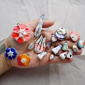 Handgjorda porslinsberlocker med gulddetaljer