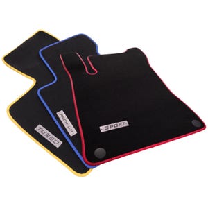 May include: Three black car floor mats with distinct colored edges in yellow, blue, and red. Each mat features a metallic rectangular badge with the text TURBO, PREMIUM, or SPORT, and includes circular black mounting points for secure installation.