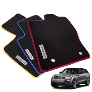 Op de afbeelding: Drie zwarte automatten met gekleurde randen in geel, blauw en rood. Elke mat is voorzien van een rechthoekig metalen plaatje met de tekst TURBO, PREMIUM of SPORT. Een zilverkleurige SUV is rechtsonder in de afbeelding ter referentie weergegeven.