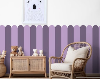 May include: A nursery room with a lavender purple accent wall featuring a scalloped border. The wall is decorated with a framed print of a koala bear. The room also features a wicker chair, a wooden cabinet, and several stuffed animals.