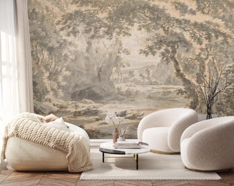 Op de afbeelding: Een woonkamerinterieur met een beige en wit gestreept behang dat een landschapsscene voorstelt. Twee witte fauteuils en een beige gebreide poef zijn voor het behang geplaatst. Een kleine ronde salontafel met een wit blad en zwarte poten staat in het midden van de kamer.