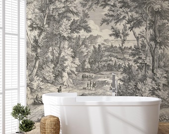 Op de afbeelding: Een wit bad staat in een badkamer met een zwart-wit vintage behang dat een bos scène afbeeldt. Het behang toont bomen, een pad en figuren in de verte. Een kleine plant in een pot staat op de vloer naast een geweven mand.