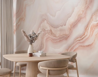 May include: A dining room scene featuring a light wood table and chairs. The wall is adorned with a large, abstract mural in shades of pink and cream, resembling marble. A vase with dried flowers sits on the table.