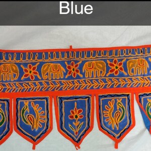 May include: A blue and orange fabric door hanging with a repeating pattern of elephants and peacocks. The hanging has a scalloped bottom edge with tassels.