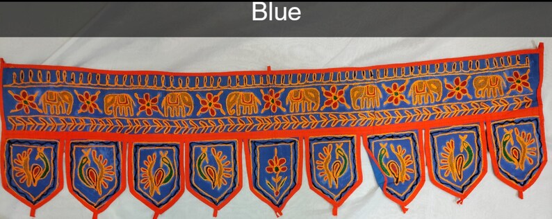 May include: A blue and orange fabric door hanging with a repeating pattern of elephants and peacocks. The hanging has a scalloped bottom edge with tassels.