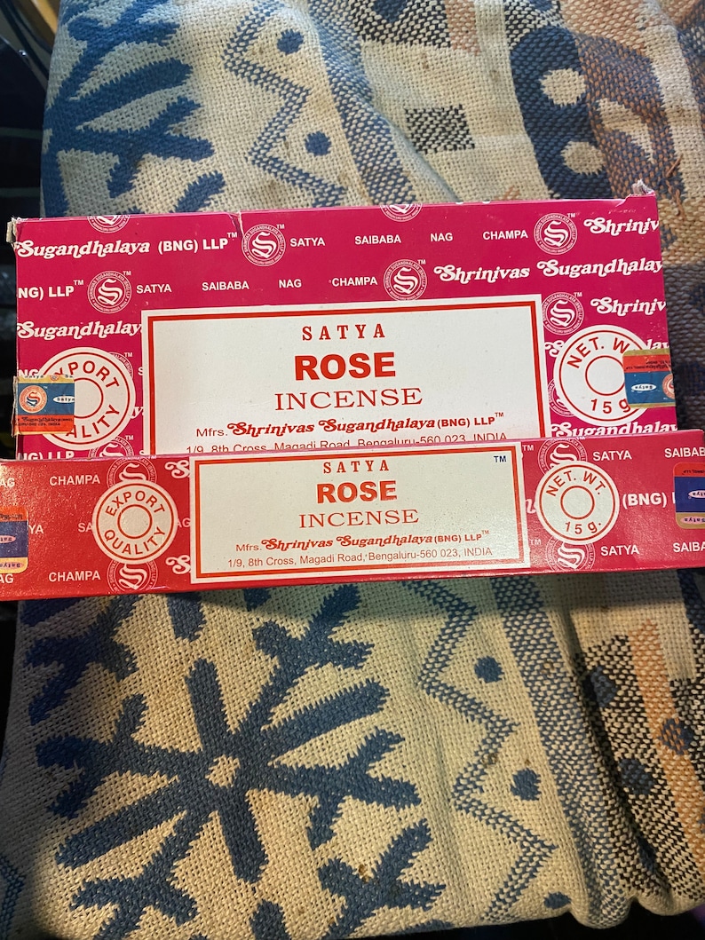May include: Two boxes of Satya Rose incense sticks. The boxes are red with white text and a gold logo. The text on the boxes reads "Satya Rose Incense" and "Mfrs. Shrinivas Sugandhalaya (BNG) LLP".