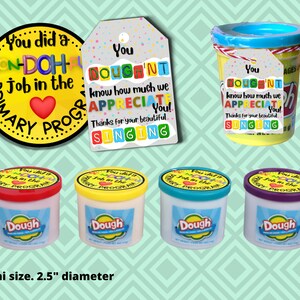 May include: Four small containers of Play-Doh modelling compound with colourful lids. Each container has a label that says "Dough" and a sticker that says "You did a Won-Doh Job in the Primary Program". The containers are 2.5 inches in diameter.