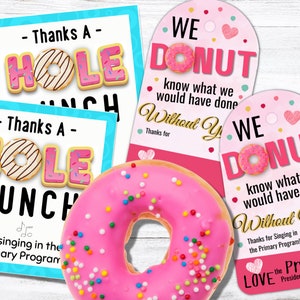 Op de afbeelding: Twee roze en witte donutvormige bedankkaartjes met de tekst "We Donut Know What We Would Have Done Without You!" en "Thanks A Hole Bunch for Singing in the Primary Program!" De kaartjes zijn versierd met roze hartjes en witte stippen. Een roze geglazuurde donut met kleurrijke sprinkels bevindt zich op de voorgrond.