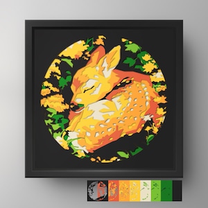 May include: A multi-layered paper art piece in a black square frame featuring a circular cutout. The design depicts a sleeping fawn in shades of orange, yellow, and white, surrounded by green and yellow foliage against a dark background.