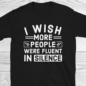 May include: Black t-shirt with white text that reads "I wish more people were fluent in silence."