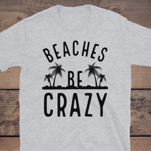 May include: Gray t-shirt with black text that reads "Beaches Be Crazy" and a graphic of palm trees.