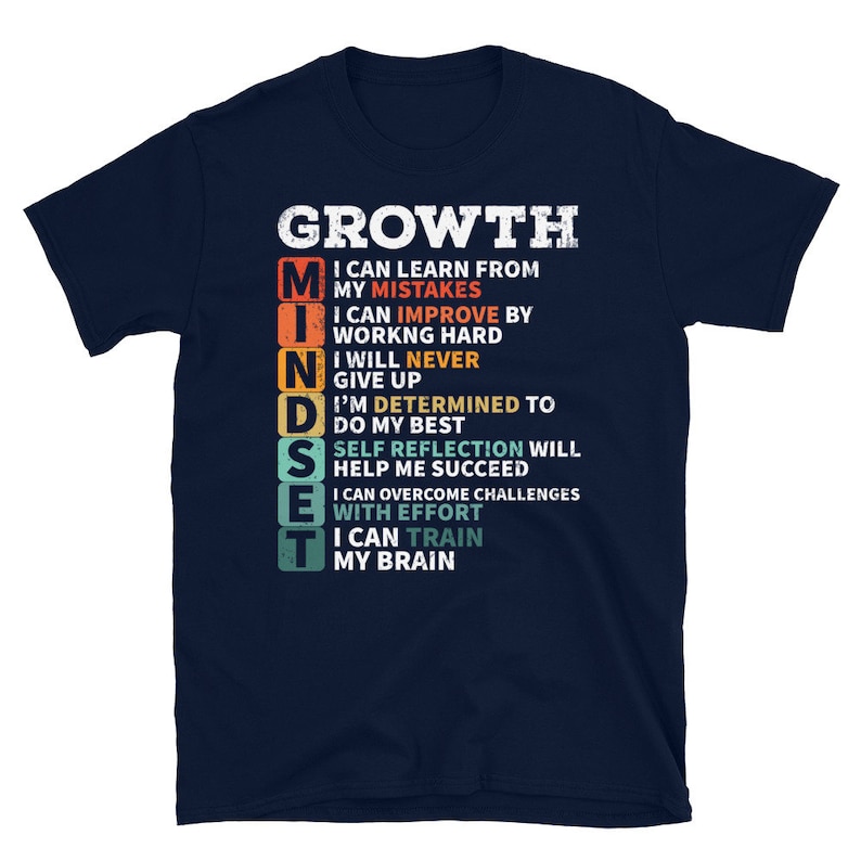 May include: Navy blue t-shirt with a white graphic that says "GROWTH MINDSET" and lists the benefits of having a growth mindset. The graphic is in a vintage style with a rainbow color scheme.