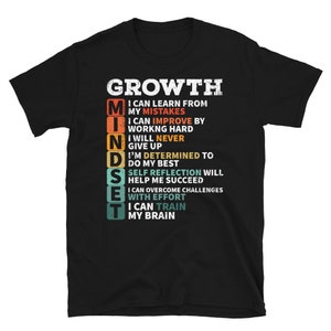 May include: Black t-shirt with a vintage-style graphic that reads "GROWTH MINDSET" and lists a series of positive affirmations about personal growth.
