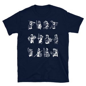Puede incluir: Una camiseta azul marino con un gr&aacute;fico blanco de los doce dioses y diosas del Olimpo. El gr&aacute;fico incluye a Zeus, Hera, Poseid&oacute;n, Dem&eacute;ter, Atenea, Apolo, Artemisa, Ares, Afrodita, Hefesto, Hermes y Dionisio.