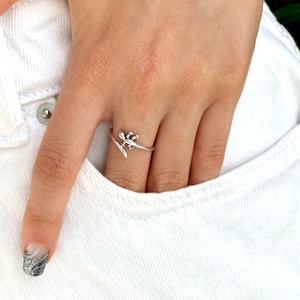 May include: A silver ring with a lizard design. The ring is wrapped around the finger and the lizard is facing to the right.