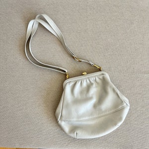 A small light gray leather purse with a gold clasp shoulder women’s bag vintage