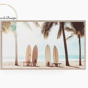 May include: Four surfboards leaning against a wooden bench on a sandy beach with palm trees in the background. The sky is blue and the ocean is turquoise.