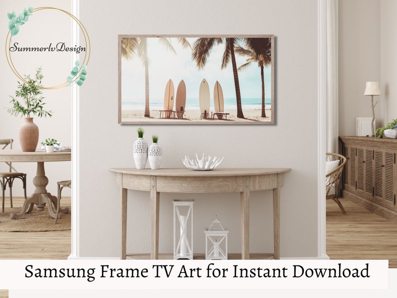 May include: A digital art print of surfboards on a beach with palm trees. The print is in a light brown frame and is hanging on a wall above a wooden console table. The print is perfect for a beach-themed home decor.