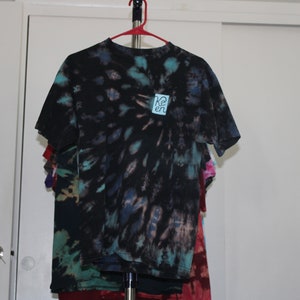 May include: A black tie-dye t-shirt with a blue and white square patch that says "Re:en" on it.