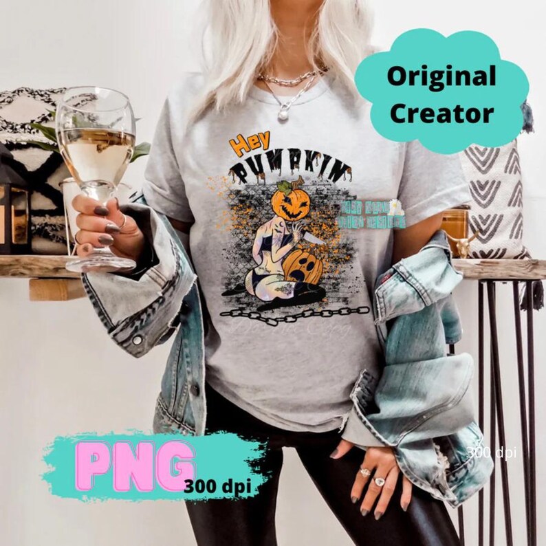 May include: A gray t-shirt with a graphic of a pumpkin-headed woman holding a knife and a pumpkin. The text "Hey Pumpkin" is above the graphic.