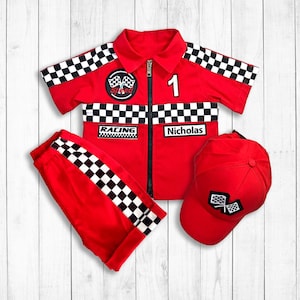 May include: Red racing suit with black and white chequered pattern, a red cap with a chequered flag design, and the name "Nicholas" on the suit.