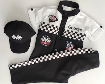 May include: A black and white checkered racing-themed outfit for a child. The outfit includes a white shirt with black checkered trim, a black and white checkered patch, and a black cap with a checkered flag design. The shirt has a black collar and a button closure. The shirt also has the word "George" printed on the front. The outfit is perfect for a child who loves racing.
