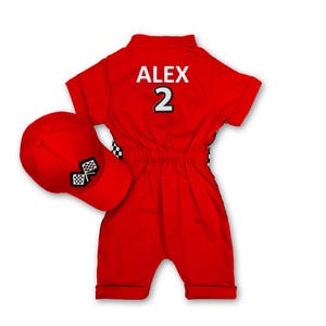 Back view of the red baby racing romper. The name "ALEX 2" is written in large white letters with professional embroidery. This personalised detail makes the romper look like a real racing pilot uniform and creates a lasting memory for special occasions like birthdays.