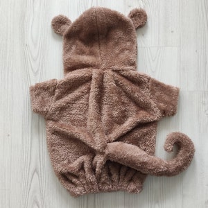Puede incluir: Disfraz de mono de peluche marr&oacute;n para mascotas. El disfraz tiene una capucha con orejas, una cola y una cremallera.