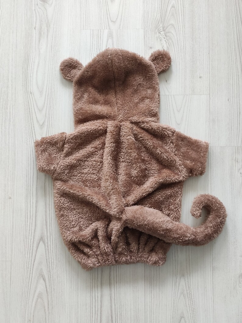 Puede incluir: Disfraz de mono de peluche marr&oacute;n para mascotas. El disfraz tiene una capucha con orejas, una cola y una cremallera.