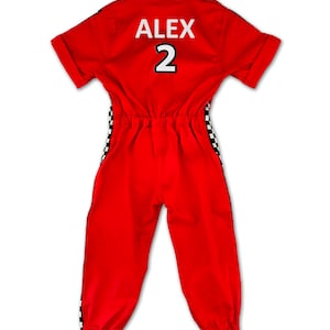 Kids racing suit costume set – vibrant red jumpsuit with black-white checkered stripes, race car details, and elastic ankle design. Includes red racing cap. Personalized with name and number on the back. Ideal for themed birthdays, costumes, and role play.