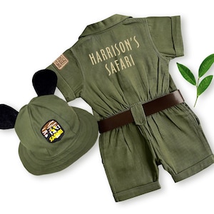 Detailed rear view of the safari explorer jumpsuit with "Harrison's Safari" custom name embroidery paired with a hat featuring black ears. Ideal for Two Wild birthday parties, this handmade costume offers a unique and playful look for toddlers.